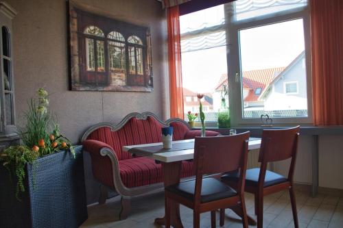 a living room with a table and chairs and a couch at Hotel Quellenhof in Salzgitter