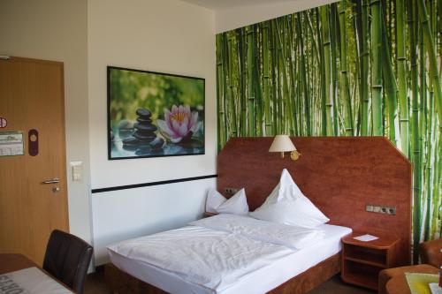 ein Schlafzimmer mit einem Bett und einem Wandgemälde in der Unterkunft Hotel Quellenhof in Salzgitter