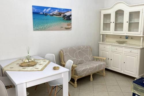 een woonkamer met een tafel en een stoel bij Casa Osiride con giardino privato e barbecue in Nulvi