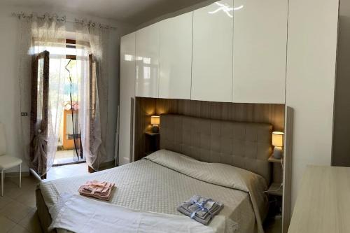 een slaapkamer met een bed met twee handdoeken erop bij Casa Osiride con giardino privato e barbecue in Nulvi
