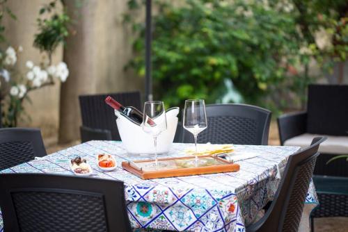 een tafel met glazen wijn en eten erop bij Casa di Betty in Càbras