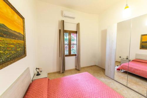 a bedroom with a pink bed and a painting on the wall at Casa di Betty in Càbras