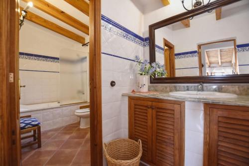 a bathroom with a sink and a toilet and a mirror at Cocons in Sineu