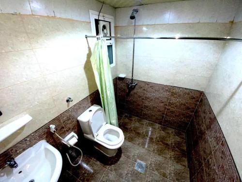 a bathroom with a toilet and a sink at Savoy Inn Hotel Apartments in Muscat