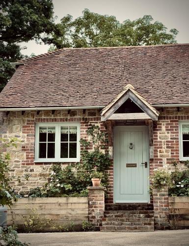 a brick house with a blue door and windows at Plum Henley in Henley