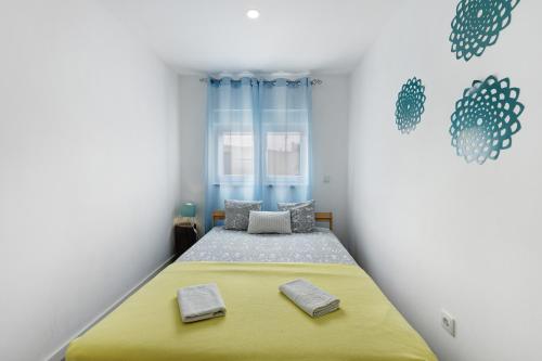 1 dormitorio con 1 cama amarilla y 2 toallas en Zen Village Amarela, en Fernao Ferro