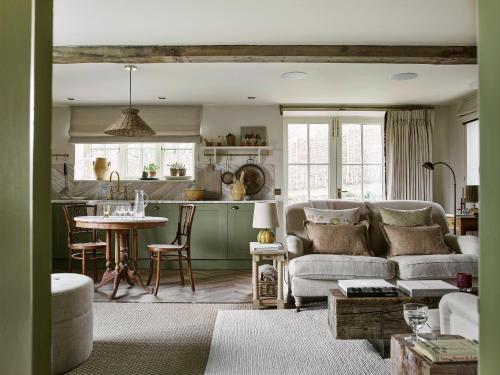 a living room with a couch and a kitchen at Plum Henley in Henley