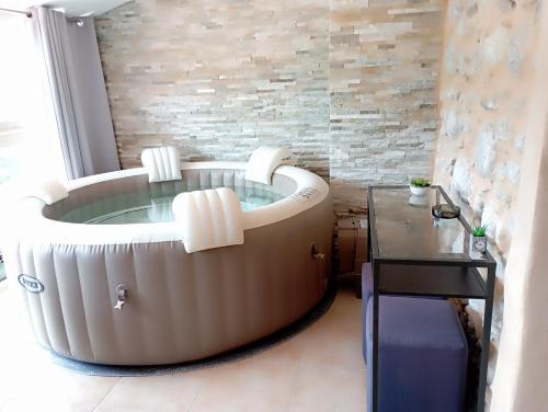 een bad in een kamer met een tafel bij Logis Hotel Restaurant Mas de la Prairie in Le Vigan
