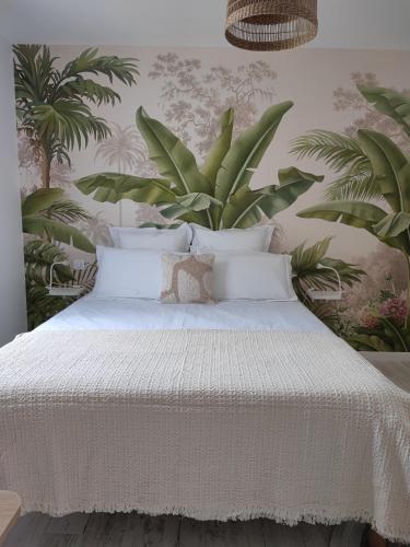 - une chambre dotée d'un lit avec des draps blancs et des plantes dans l'établissement La Parenthèse Cormillonne, à Corme-Écluse