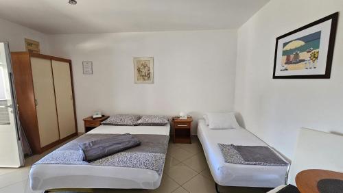 ein Zimmer mit zwei Betten und zwei Tischen in der Unterkunft Apartment house Berry in Primošten