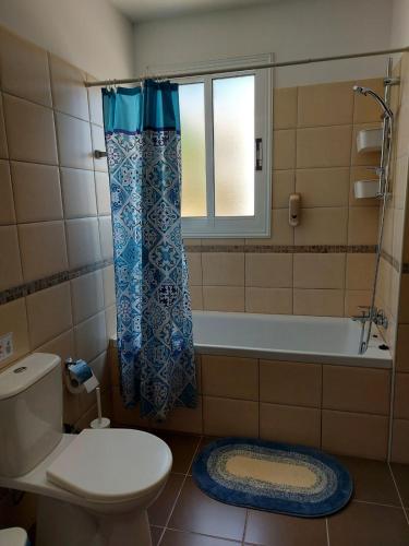 a bathroom with a toilet and a tub and a window at Pyla Palms A2 107 in Pyla