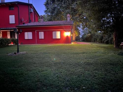 a red house with a light on the side of it at TENUTA FERRARI in Cortile