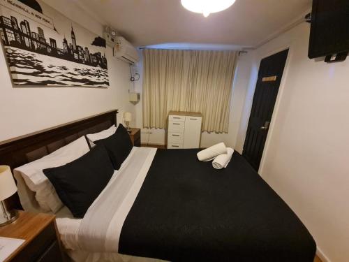 um quarto com uma cama com lençóis brancos e pretos em Bellavista express em Santiago