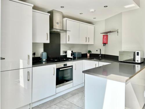 una cocina blanca con armarios y electrodomésticos blancos en Montrose House en York