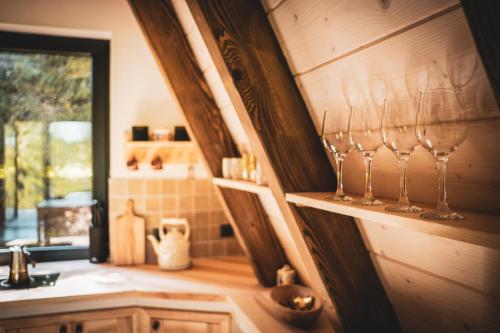 a kitchen with wine glasses on a shelf at Grzechatka in Wetlina