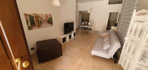 a living room with a white couch and a television at Gentilcasa in Monopoli