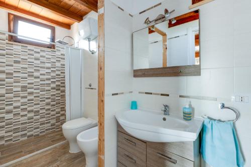 a bathroom with a sink and a toilet at Villino Turchese in Càbras