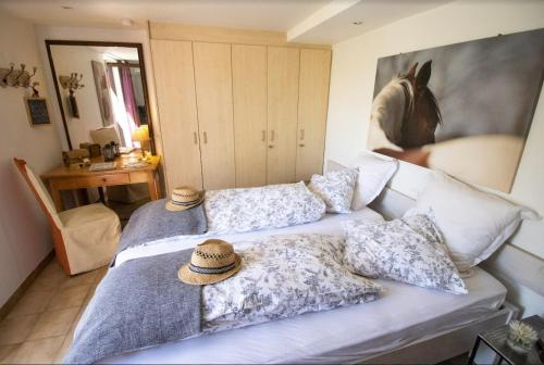 ein Schlafzimmer mit zwei Betten mit Hüten darauf in der Unterkunft Maison d'hôtes du Mont in Morschwiller