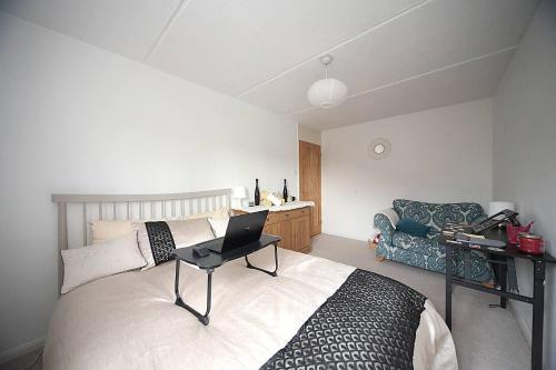 1 dormitorio con 1 cama y escritorio con ordenador portátil en Stunning 1-Bed Apartment in Milton Keynes en Milton Keynes