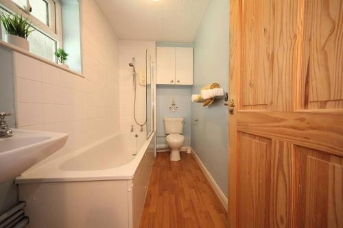 Stunning 1-Bed Apartment in Milton Keynes في ميلتون كينز: حمام مع مرحاض وحوض استحمام ومغسلة