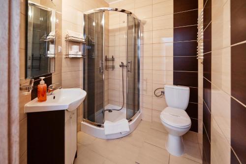 a bathroom with a shower and a toilet and a sink at VIPABO SolneSPA - Sauna, Grota Solna, Łaźnia parowa in Niechorze
