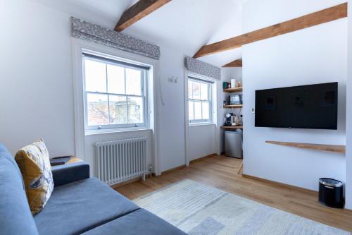 a living room with a couch and a flat screen tv at Apartment 5 at Number 8: 1 bedroom, sofa bed in lounge, kitchenette & walk-in shower in Kent