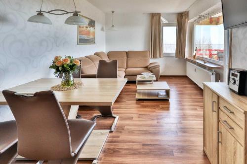 a living room with a table and a couch at Terrassenhaus, FeWo 88 in Duhnen