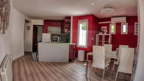 a kitchen with red walls and a table and chairs at Casa Blanca in Calpe