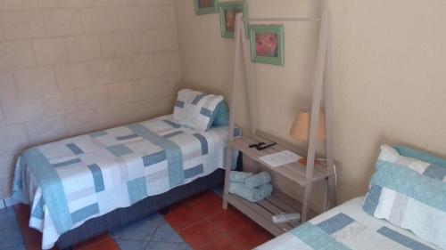a small bedroom with two beds and a mirror at ASAMé @ Oppi-Rivier in Christiana