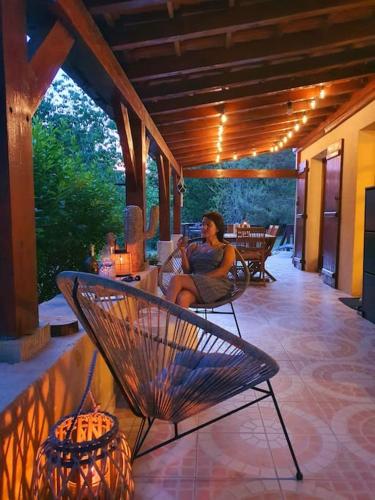 a woman sitting in a chair on a patio at Maison Calme au Cœur du Périgord Noir - 3 Chambres in Le Bugue
