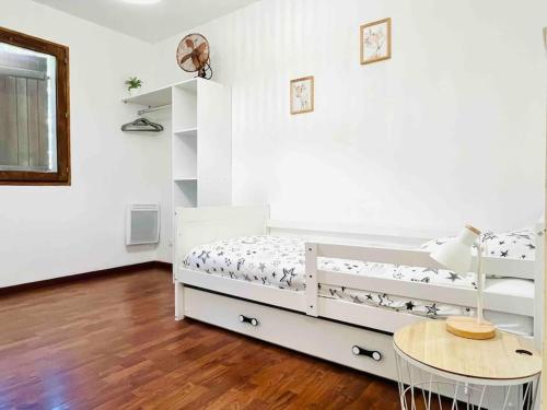 a white room with a bed and a table at Maison Calme au Cœur du Périgord Noir - 3 Chambres in Le Bugue