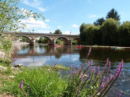 a bridge over a river with boats on it at Maison Calme au Cœur du Périgord Noir - 3 Chambres in Le Bugue