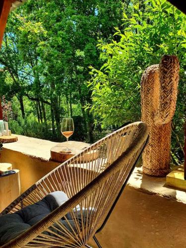 a chair sitting on a porch with a glass of wine at Maison Calme au Cœur du Périgord Noir - 3 Chambres in Le Bugue