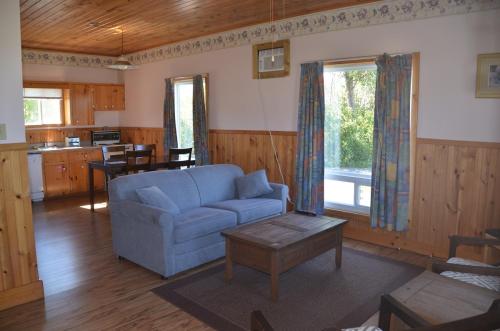 a living room with a blue couch and a table at Sundance Cottages in Cavendish