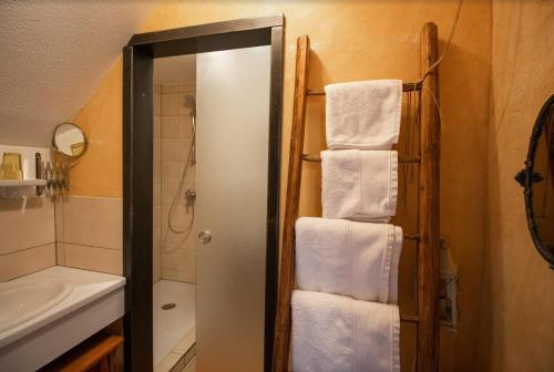 ein Bad mit einer Dusche, einem Waschbecken und Handtüchern in der Unterkunft Maison d'hôtes du Mont in Morschwiller
