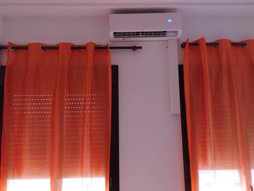 a window with orange curtains in a room at Apartamento casco histórico de Calatayud in Calatayud