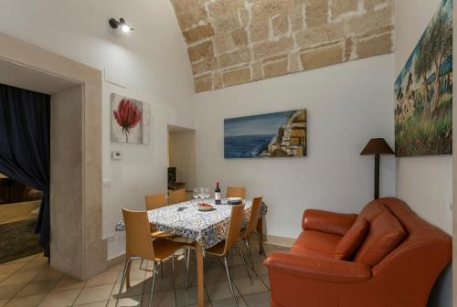 a living room with a dining room table and chairs at Suite Paisiello in Lecce