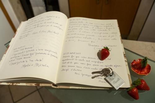 an open book sitting on a table with strawberries at Suite Paisiello in Lecce
