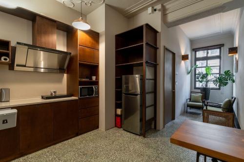 a kitchen with a refrigerator and a table in a room at 安樓文旅Enzo House in Keelung