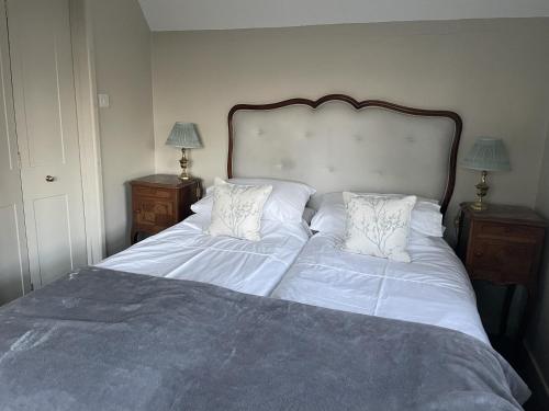 a bedroom with a large bed with white sheets and pillows at The Old Coach House in Redlynch