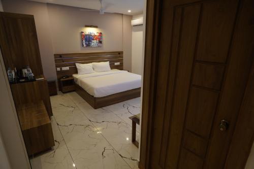 a bedroom with a bed and a room with a mirror at PUTHUR RESIDENCY HOTELS PVT LTD in Trichūr