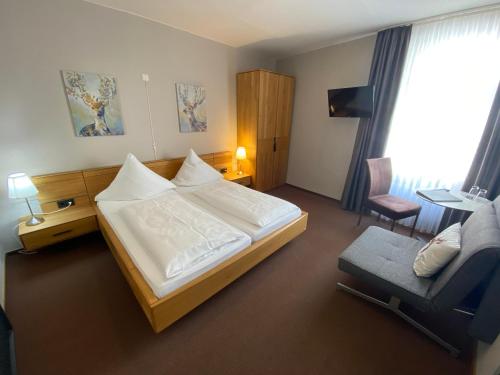 a hotel room with a bed and a chair at Weingutshotel Piesporter Goldtröpfchen in Piesport