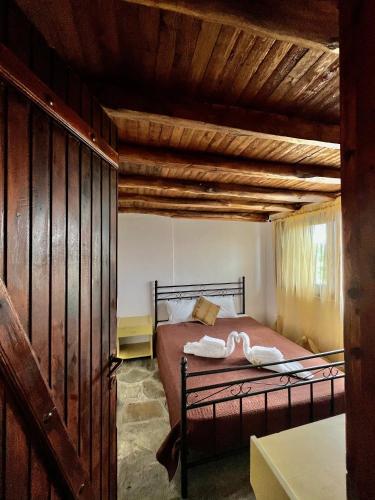 a bedroom with a bed in a room with wooden ceilings at Blue Garden Inn in Fourka