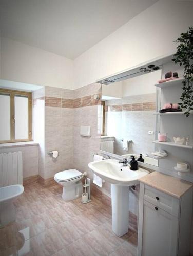 a white bathroom with a sink and a toilet at la casa dei nonni in Musellaro