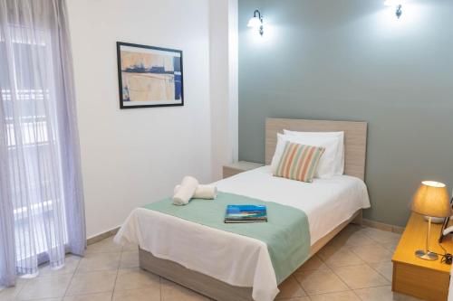 a bedroom with a bed with a book on it at Cozy Central Home Heraklion in Heraklio