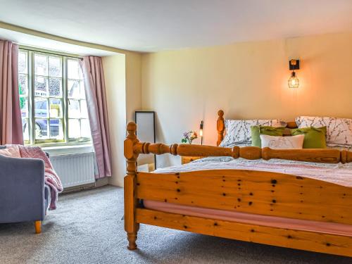 a bedroom with a wooden bed and a window at Eton Cottage in Minehead