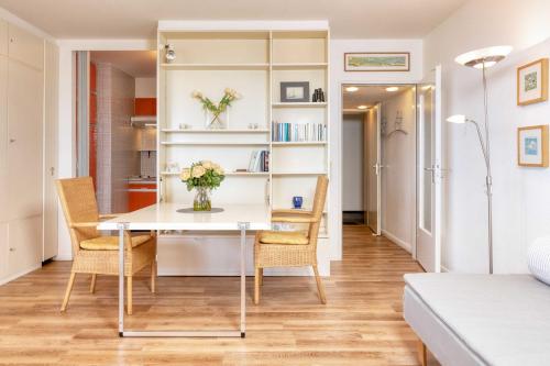 a dining room and living room with a table and chairs at Terrassenhaus, FeWo 86 in Duhnen