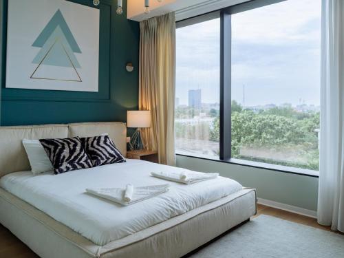 a bedroom with a bed and a large window at The Heights of Sophistication - Panoramic Views in Bucharest