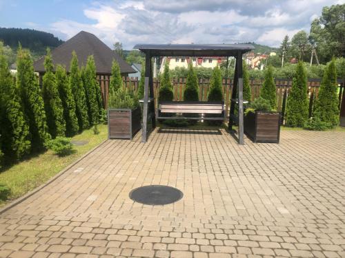 a bus stop with a bench in a garden at TOTEM in Skhidnitsa