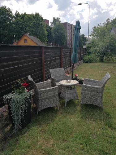 un patio con mesa, sillas y sombrilla en SKA Anykščiai, en Anykščiai